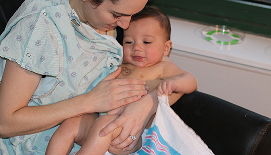 A baby wears early iterations of the John Rogers team’s soft, thin, flexible devices. The wireless, wearable devices replace the tangle of wire-based sensors that currently monitor newborns’ vital signs and pose a barrier to skin-to-skin contact and physical bonding between parents and their children.
